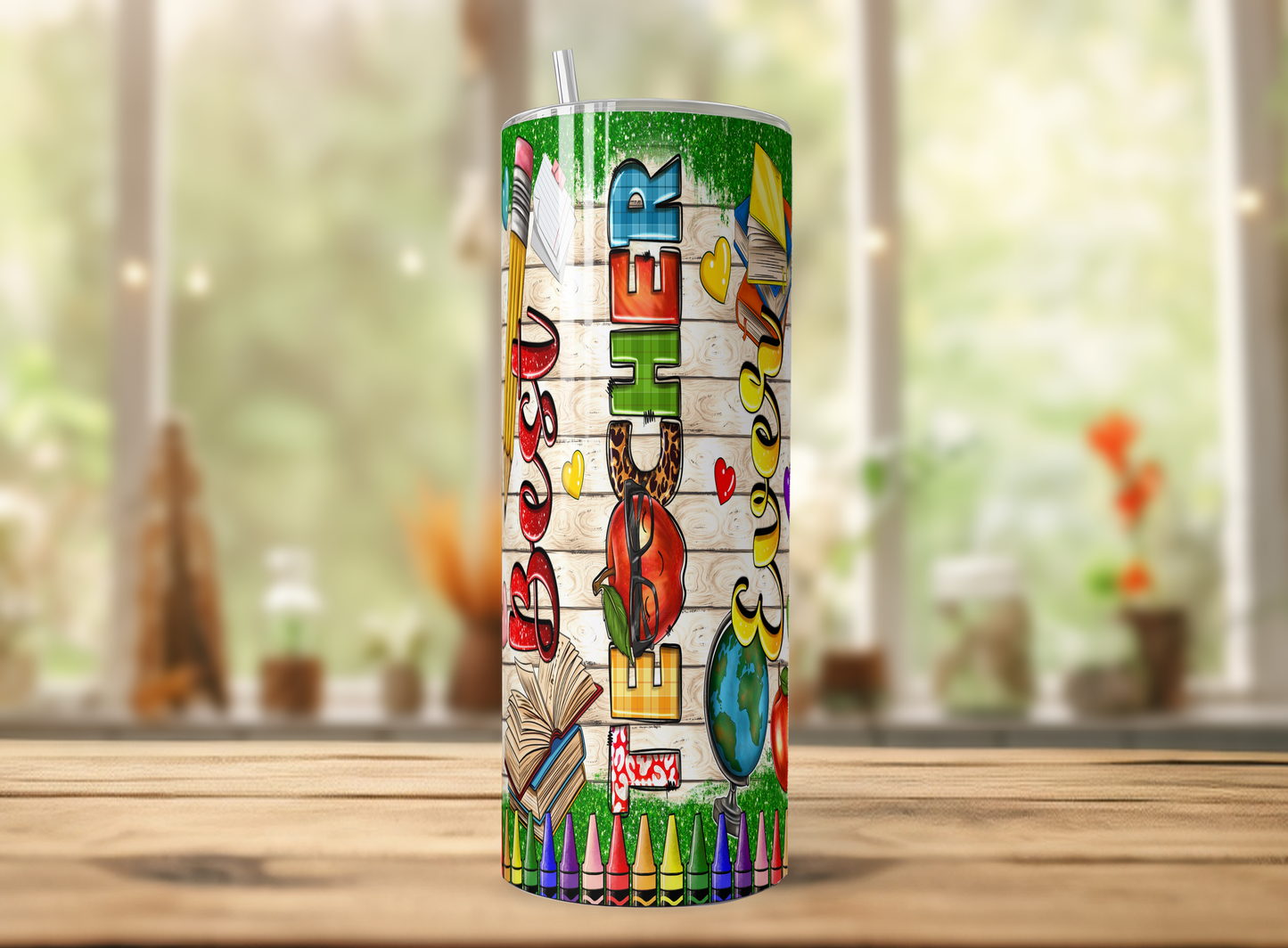 A colorful tumbler with a straw, featuring various school-related icons and text, such as a pencil, book, globe, and the word "HER".