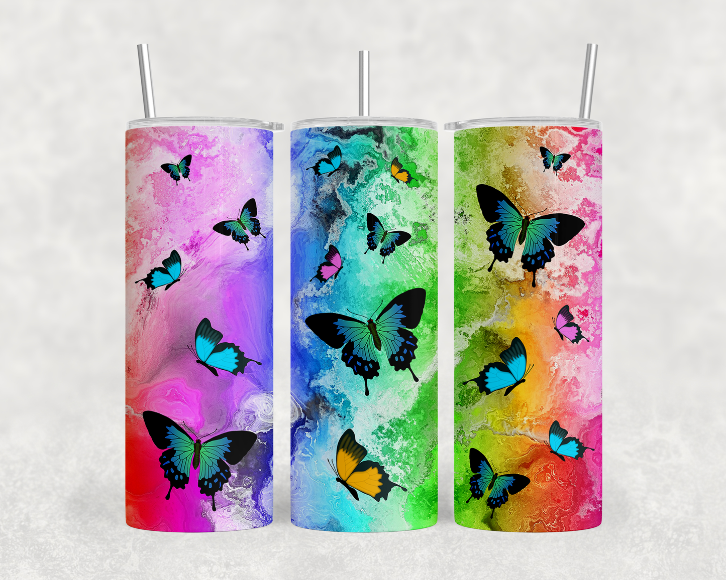 three colorful tumblers with a butterfly design. Each tumbler has a different color scheme, with the first one being pink, the second one being blue, and the third one being green. The tumblers have straws on top, and there are multiple butterflies depicted on each tumbler.