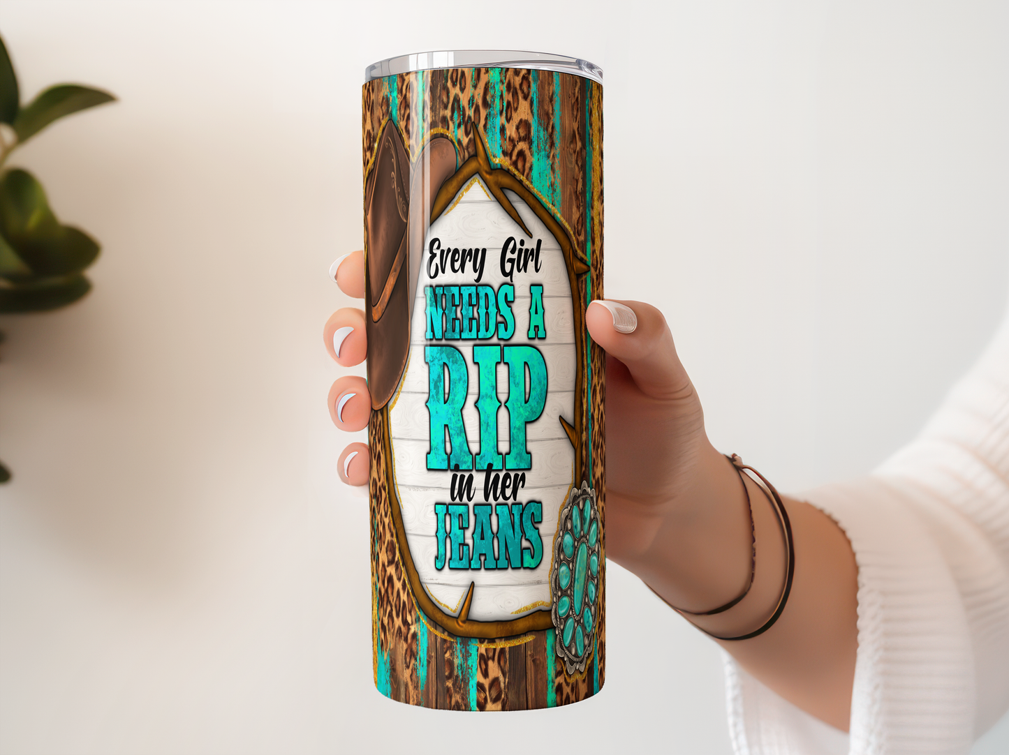 A person's hand holding a tall, cylindrical container with a colorful, leopard print design and text printed on it.