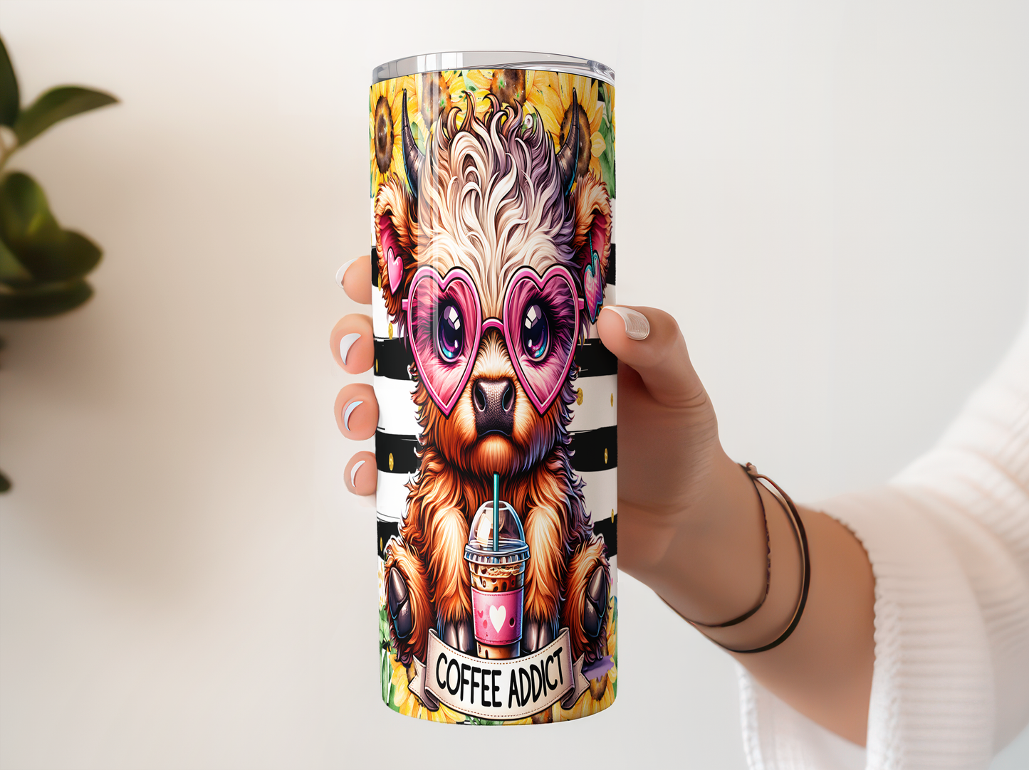 A person's hand holding a colorful coffee cup with a cartoon image of a bear wearing sunglasses and holding a coffee cup.